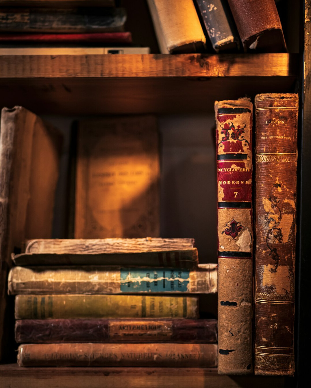 Shelf of old books in warm light
